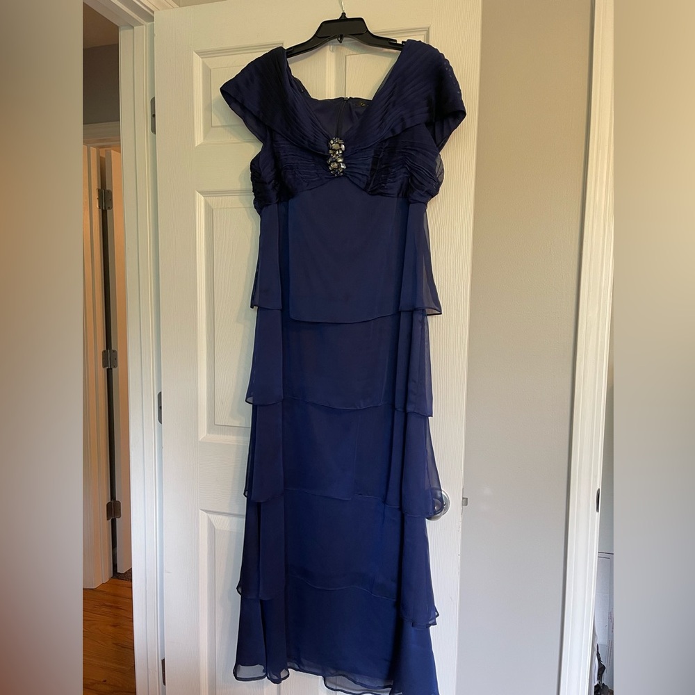 Navy blue evening gown with sequined broach at the chest.
